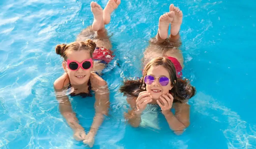 Happy cute girls in swimming pool 