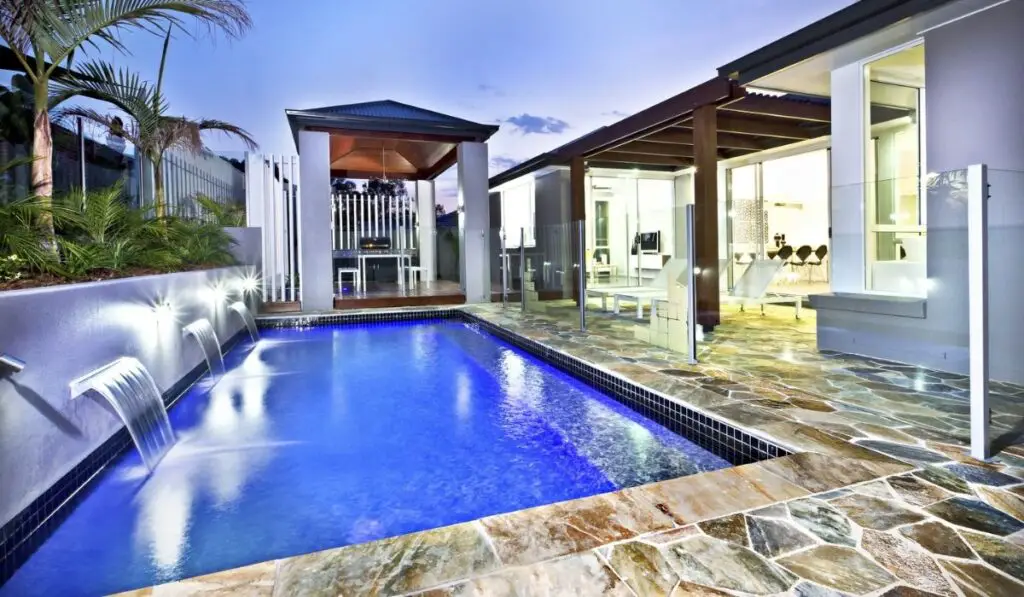 Modern swimming pool side with glass cover at night 