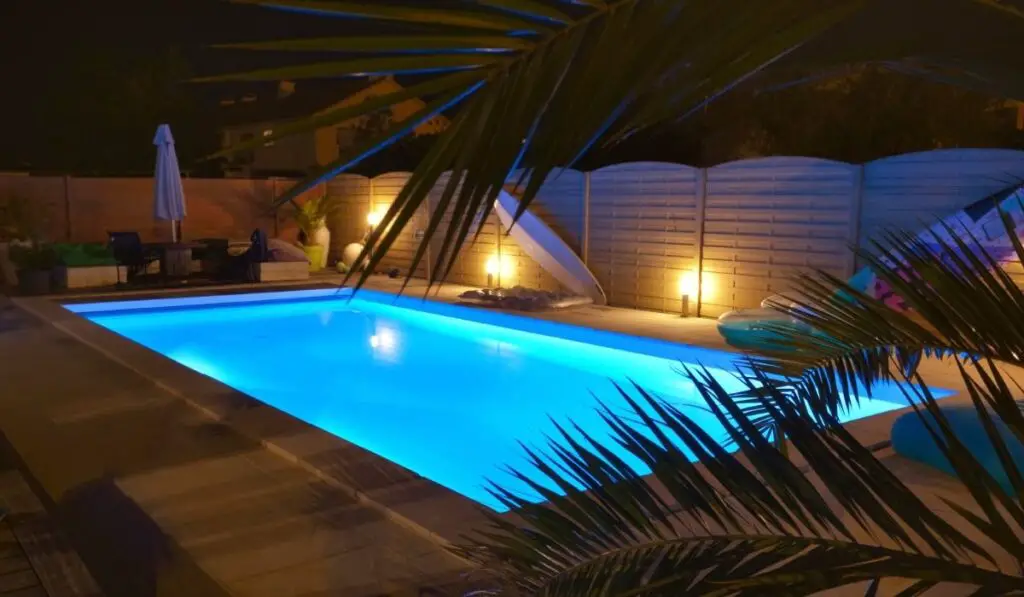 Water od swimming pool illuminated in blue by night 