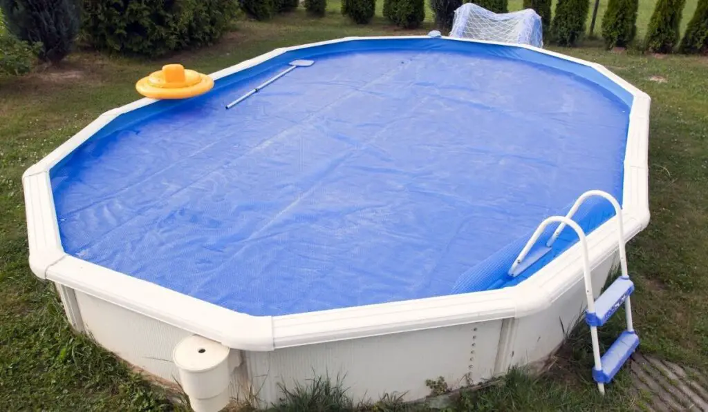 Home pool covered with solar cover