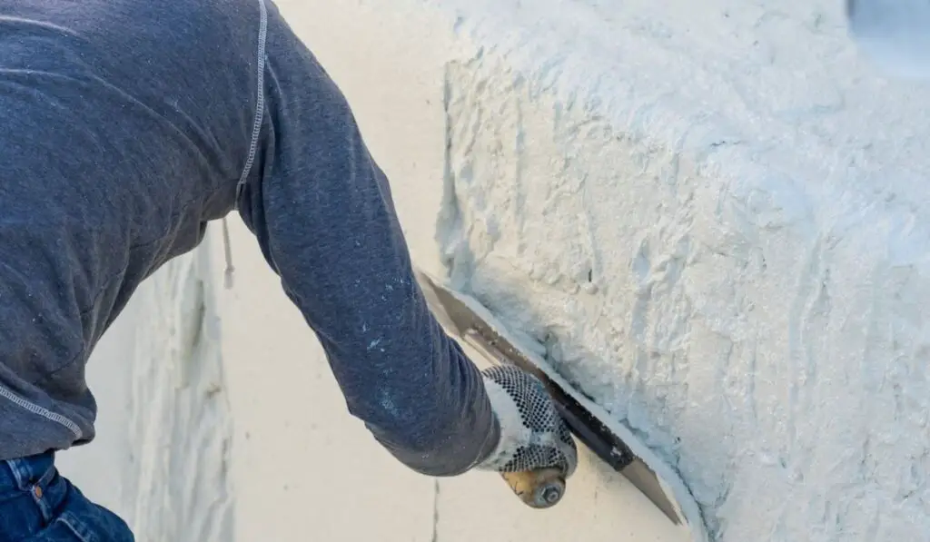 Worker Smoothing Wet Pool Plaster With Trowel 