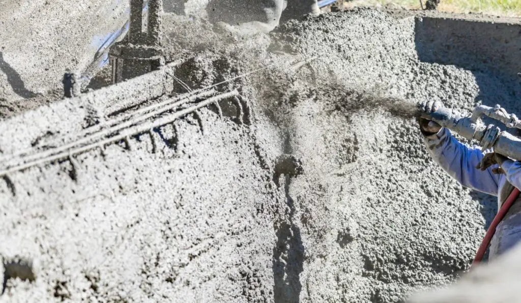 Pool Construction Worker Shooting Concrete, Shotcrete or Gunite Through Hose