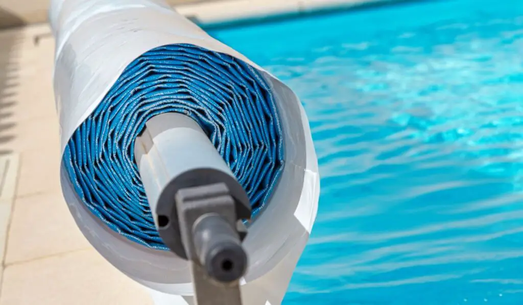 Pool cover on the edge of a pool during the summer 