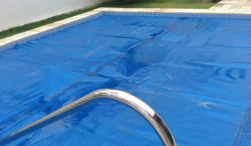 Pool in backyard with a thermal cover