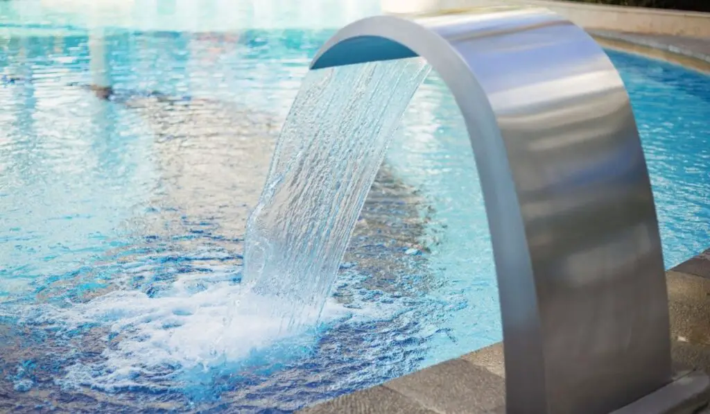 Blue water flowing into the pool 