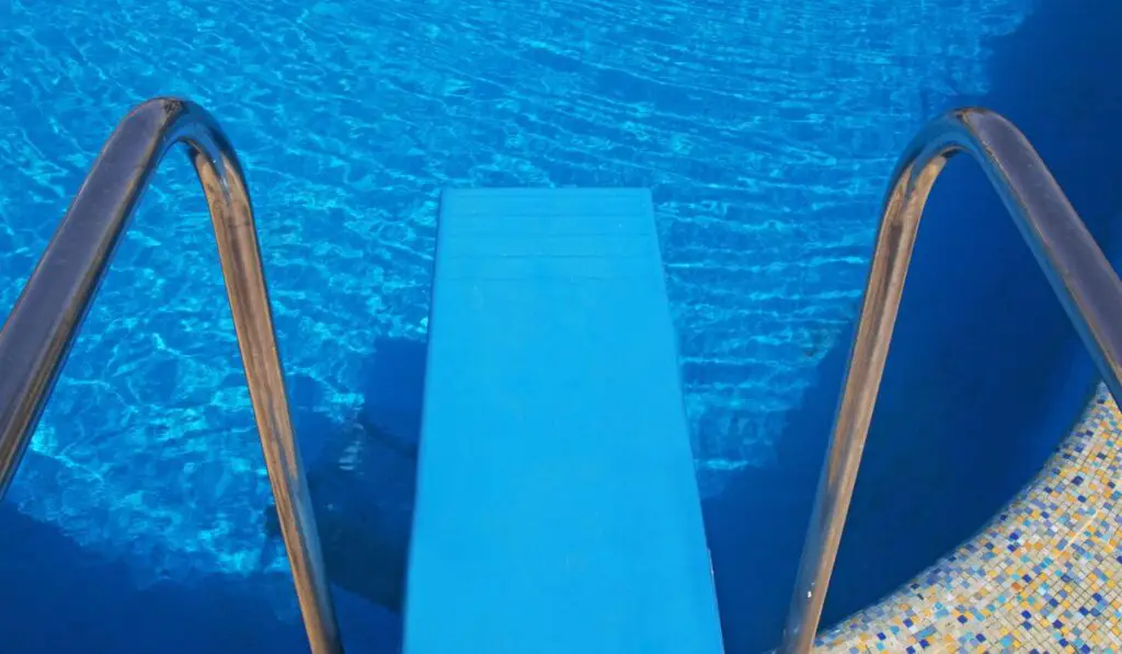 Diving board and blue swimming pool 