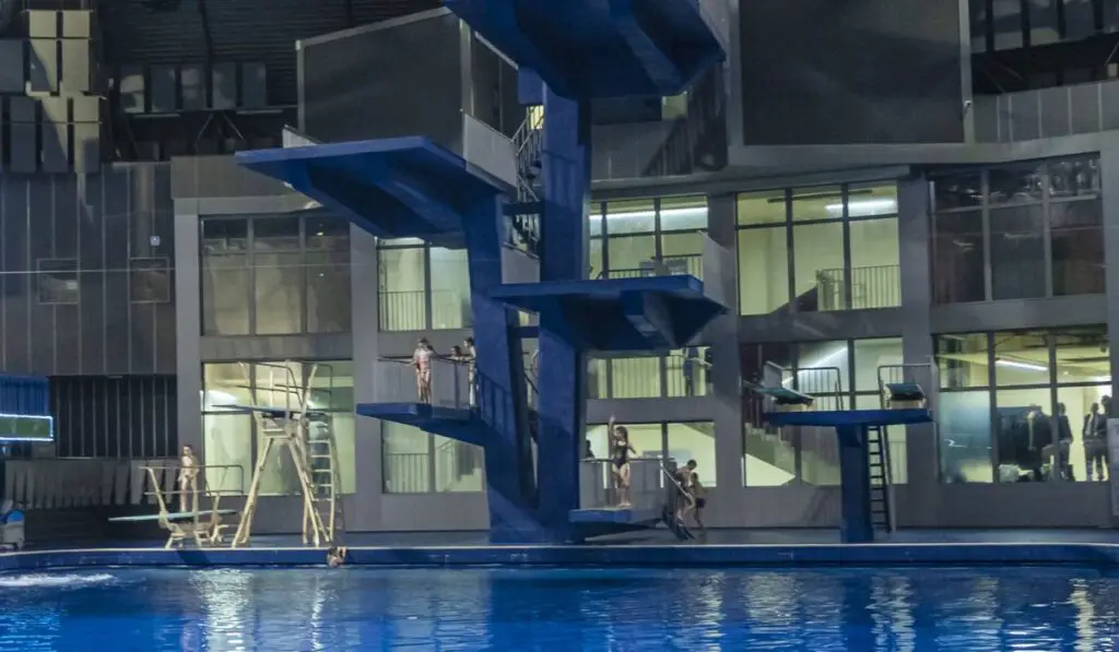Public swimming pool with jump tower and classic blue water