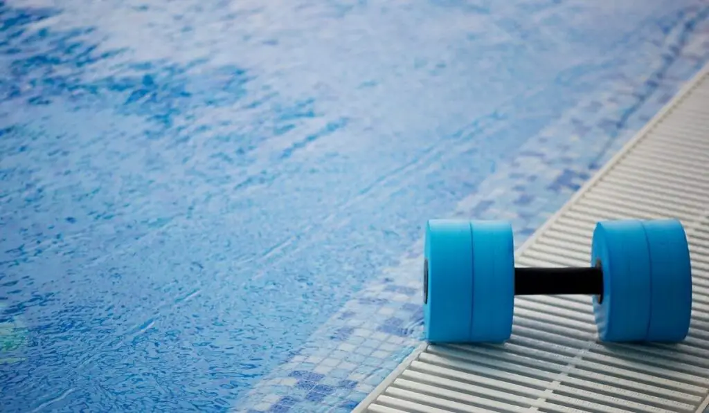The kettlebell for water aerobics lies on the edge of the pool 