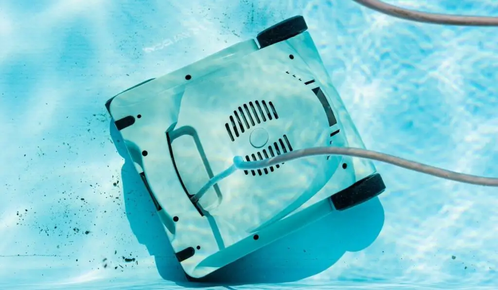 Top view of an automatic robotic pool vacuum cleaner cleaning the dirt on the floor 
