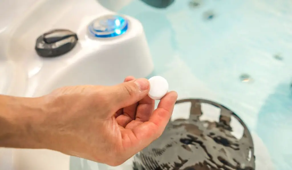 Caucasian Men Using Chlorine Tabs in a Hot Tub Spa to Maintain Healthy and Quality Water in the Bathtub