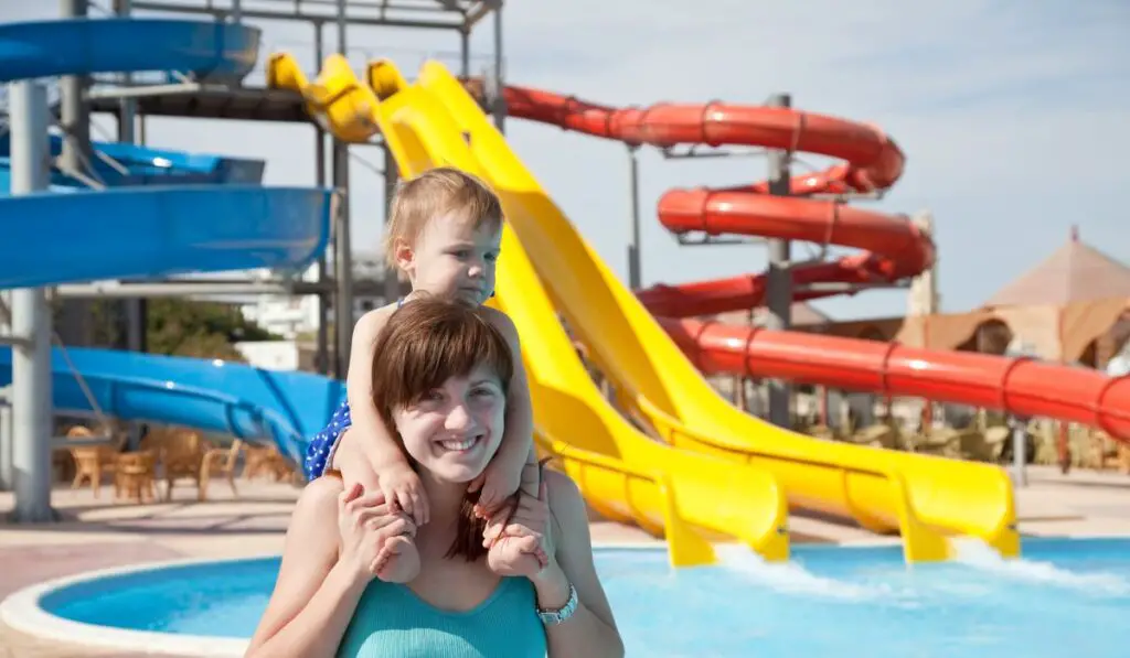 Happy mother with toddler at aquapark 