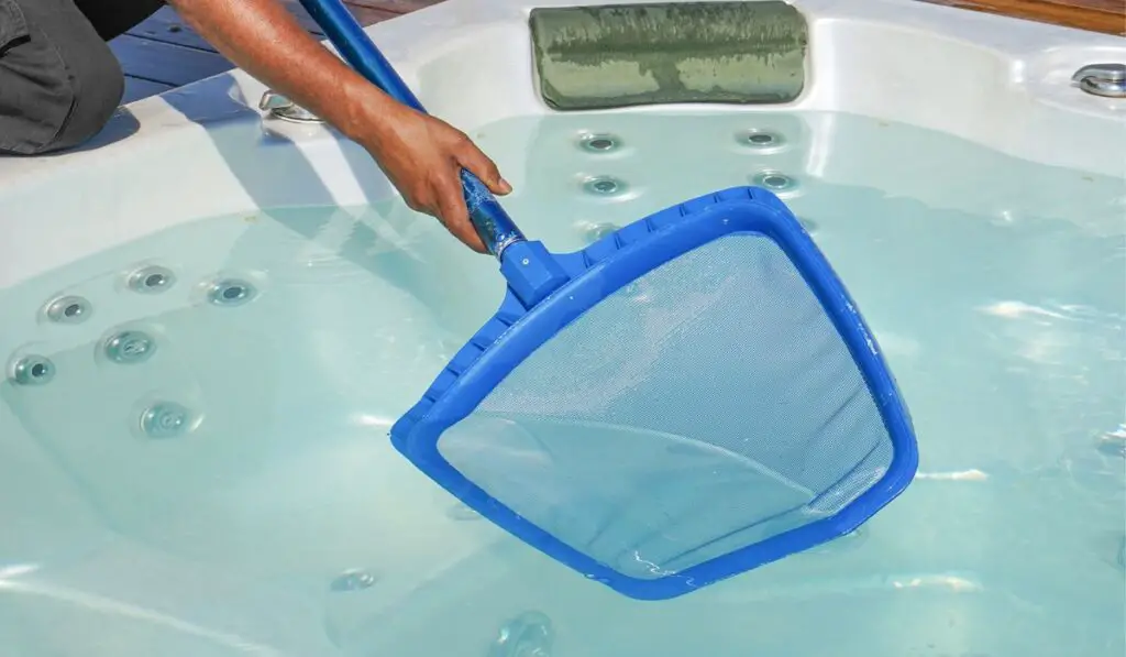 Hotel staff african worker cleaning the hot tub