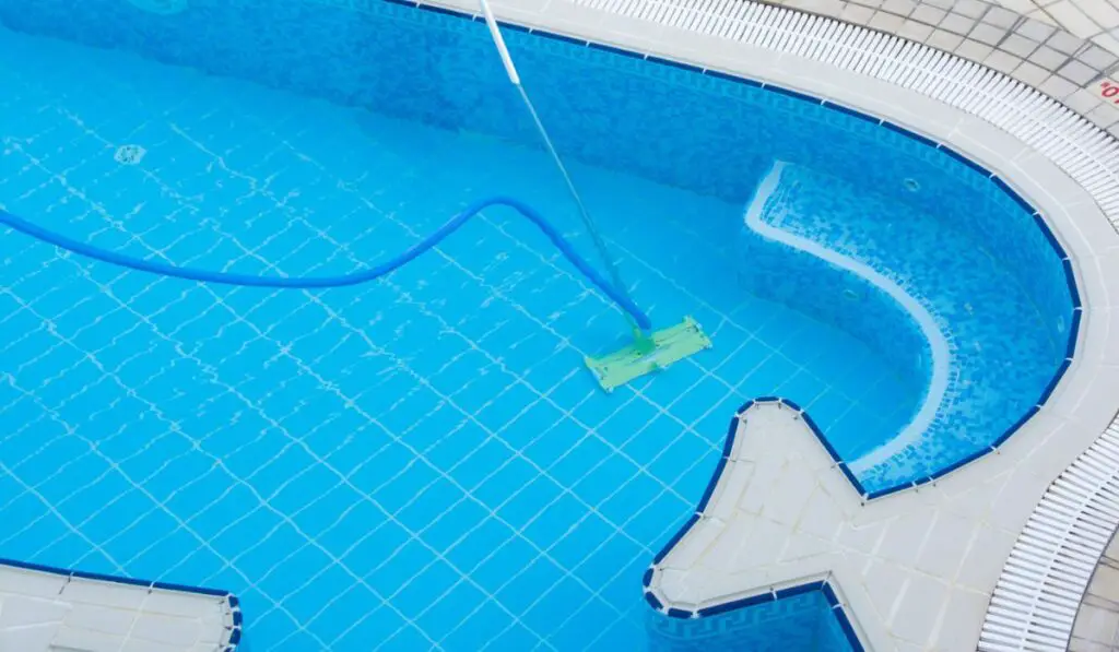 Man vacuuming the bottom of the pool