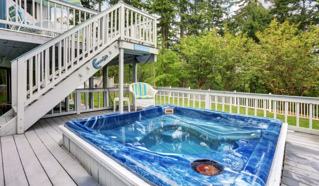 Perfect hot tub on gray deck of modern home 