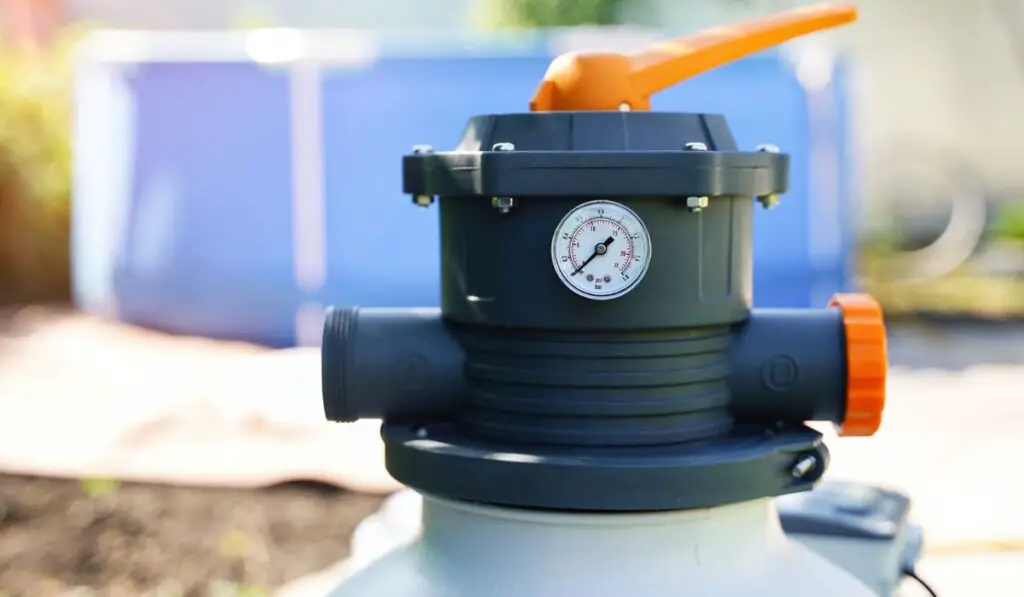 Pressure gauge measuring water pressure in a sand pump of an outdoor pool filtration system