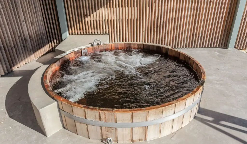 Wooden hot tub is filled with water on outdoor 