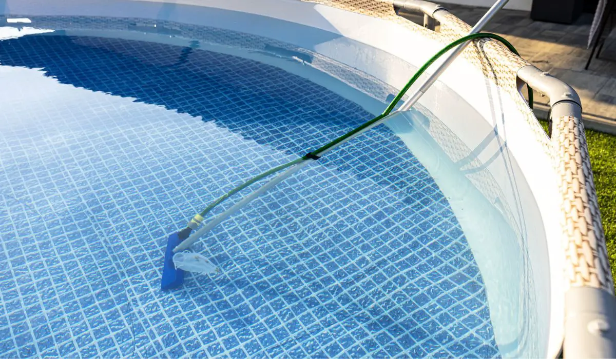 Cleaning the home pool in the garden with a brush