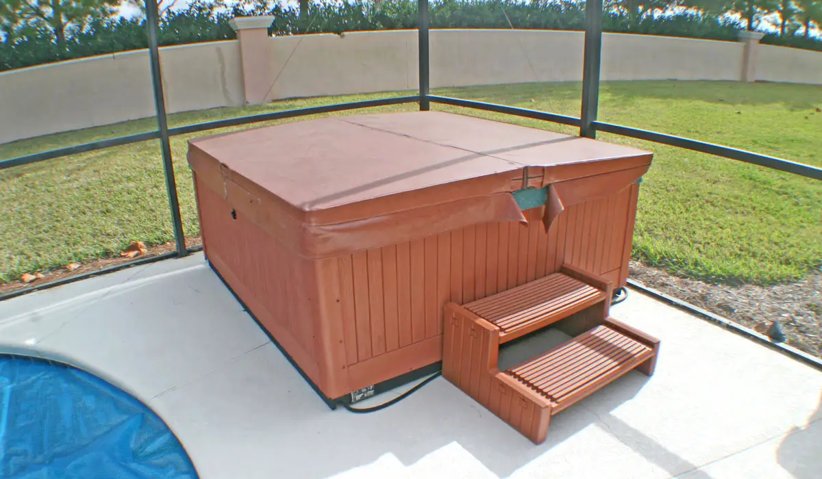 Hot tub on concrete inside of a screened in enclosure