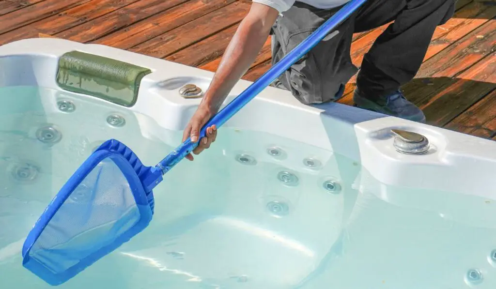 Hotel staff african worker cleaning the hot tub