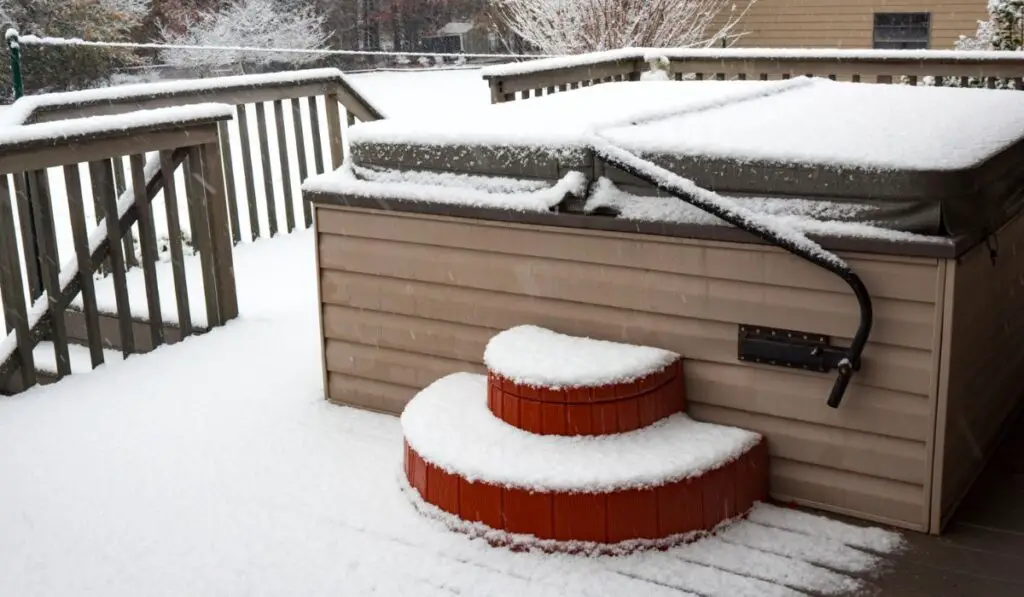 Covered hot tub on a residential porch in a snow storm