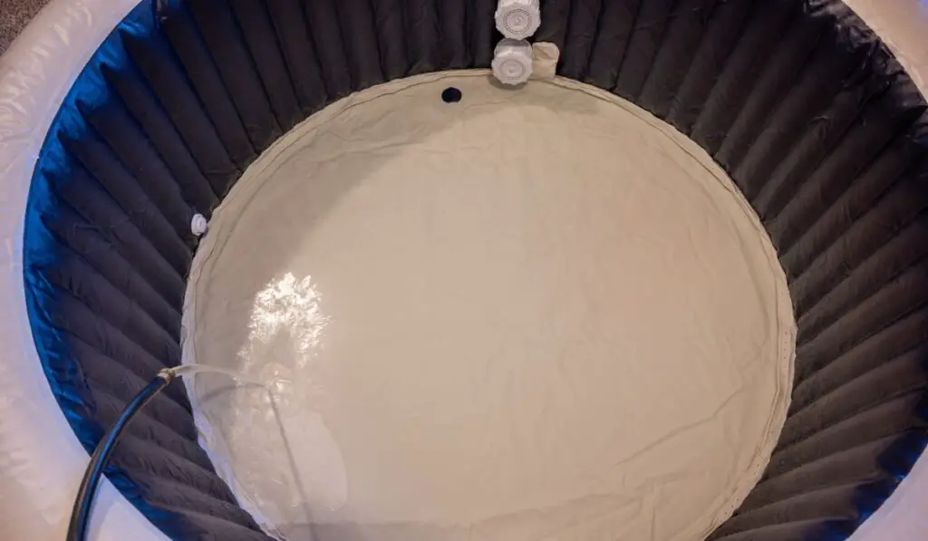 Filling an inflatable indoor hot tub inside a residential garage