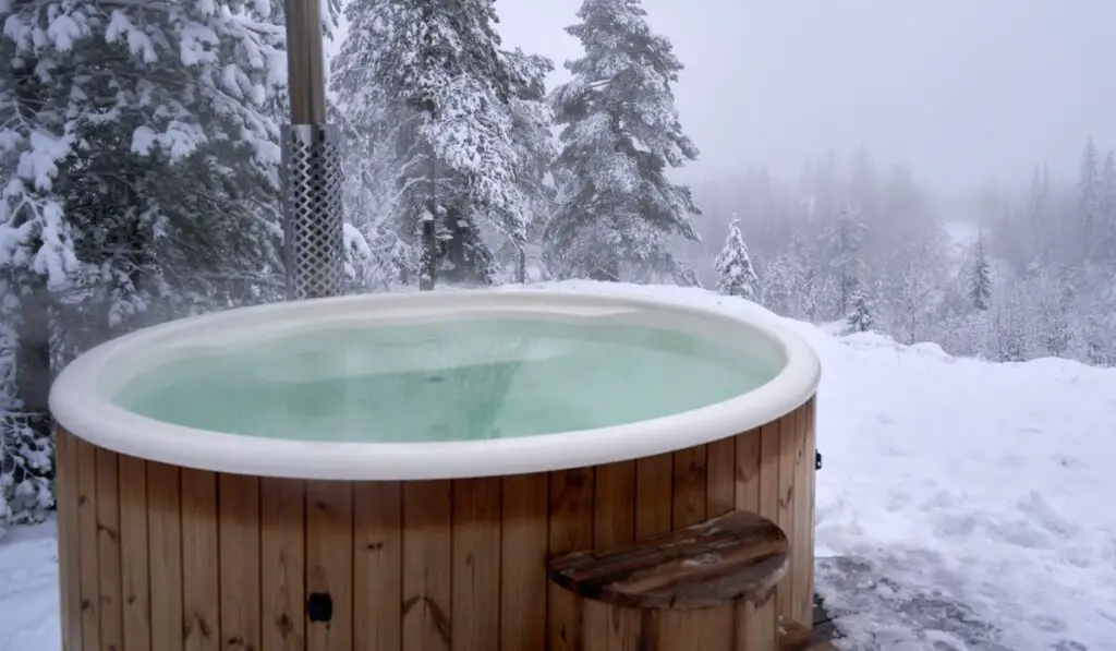 Wooden hot tub near a winter forest on a snowy day