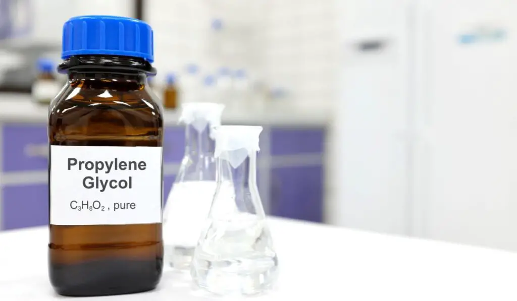 Selective focus of propylene glycol liquid chemical compound in dark glass bottle inside a chemistry laboratory with copy space
