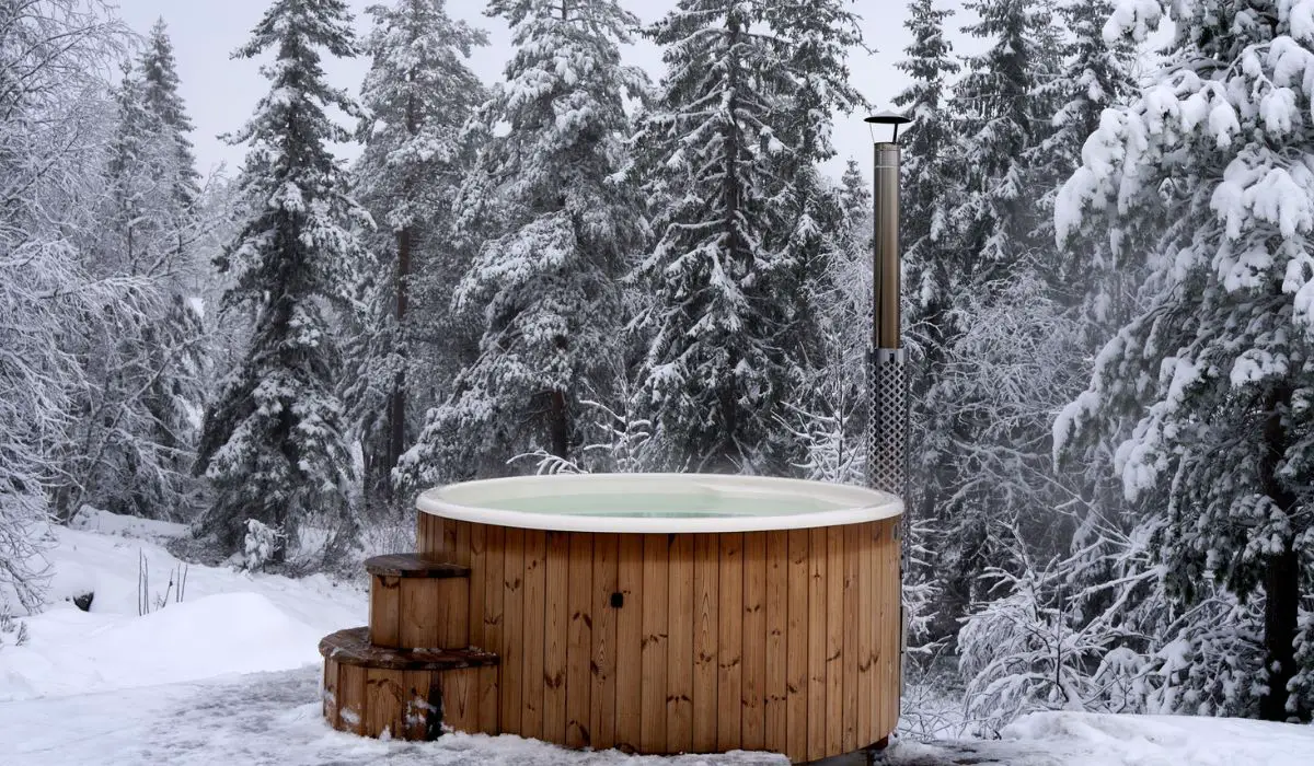Wooden hot tub near a winter forest on a snowy day