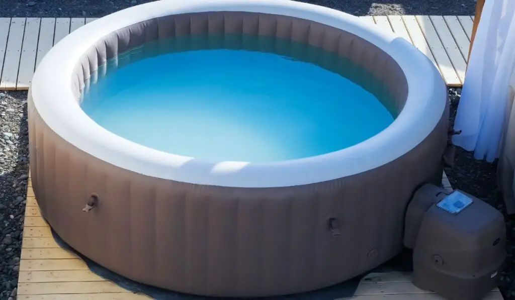 Inflatable brown and white swimming pool with turquoise water outdoors