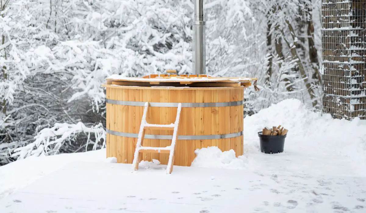 Wooden hot vat on snowy terrace at mountains