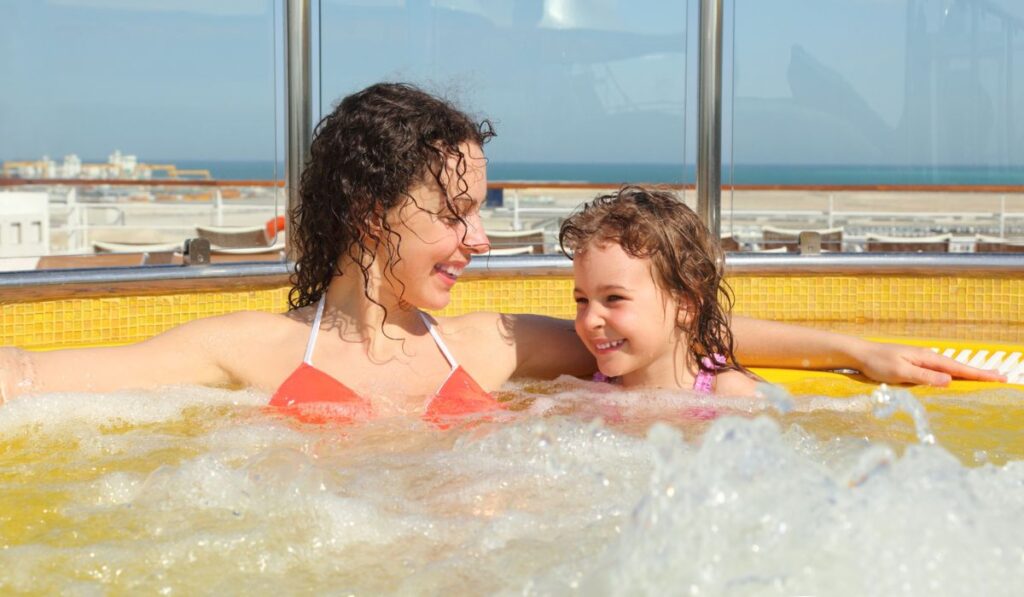 Woman with daughter both smiling in hot tub