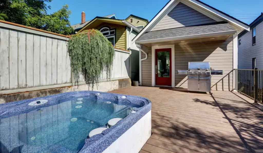 Wooden walkout deck with hot tub and barbecue