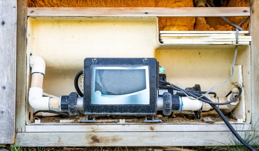 Side of hot tub with panel removed to repair and complete maintenance on the recirculation pump