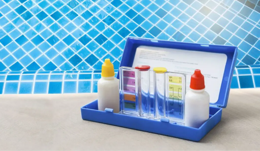 Water testing test kit for swimming pool water over blue tile background